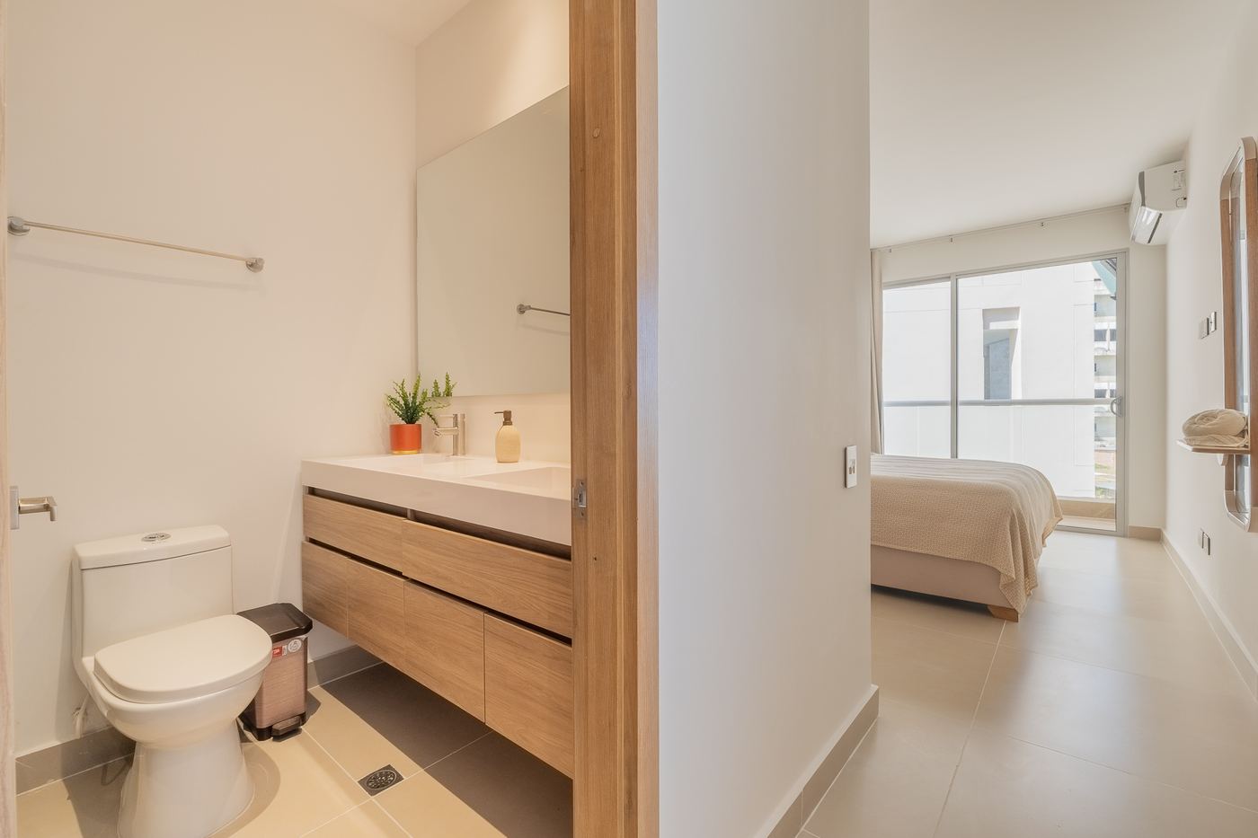 Baño y habitación principal conectados con acabados en madera